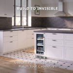 A built-in beverage cooler seamlessly integrated into a white kitchen island, showing custom panel and handle matching the surrounding cabinetry with text reading "Build to Invisible."