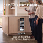 A man and woman holding drinks while standing in a modern kitchen next to a custom panel-ready beverage refrigerator built into the kitchen island.