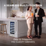 Kitchen lifestyle scene featuring a man and woman holding drinks beside an undercounter wine refrigerator built into a white kitchen island, titled "A SEAMLESS BUILT-IN DESIGN: Easy to Integrate into Custom Cabinetry.