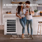 A smiling couple holding wine in a contemporary kitchen with an under-counter wine cooler seamlessly installed into the white kitchen island.