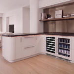 Straight-on shot of the dual-zone wine cooler fitted flush beneath gray shaker kitchen cabinets.