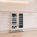 Dual-zone beverage center with matching white front panels and stainless steel handles seamlessly built into traditional white kitchen cabinetry.