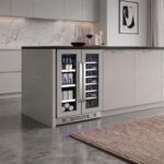 French-door under-counter cooler integrated into the end of a contemporary gray kitchen island with a concrete floor and a decanter on the countertop.